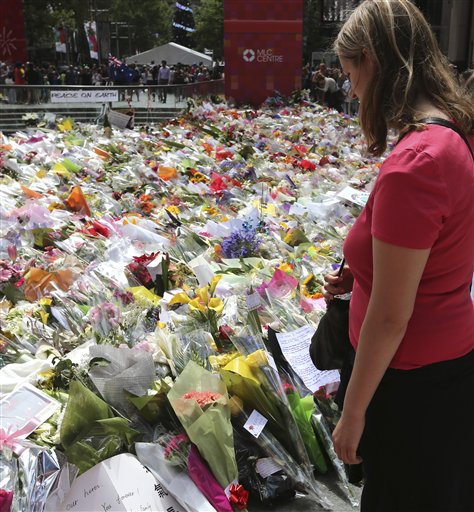 Foto: Una mujer se para para leer mensajes de recuerdo en el punto de homenaje a las víctimas de un asedio mortal, cerca del Lindt cafe donde tuvo lugar, en el distrito financiero de Sídney, Australia, el 18 de diciembre de 2014. AP / Rob Griffith