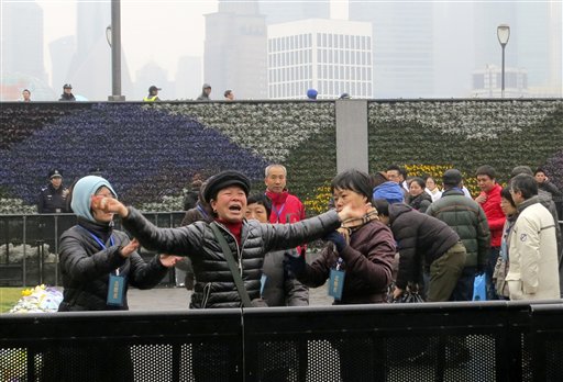 Foto: Funcionarios chinos tratan de controlar a la familiar de una víctima de la estampida de Año Nuevo en Shanghai en una ceremonia en recordación de los muertos, martes 6 de enero de 2015. / AP