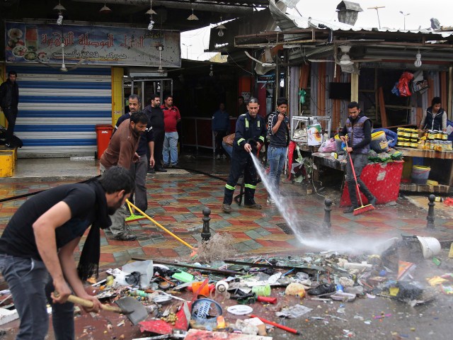 Trabajadores participan en las labores de limpieza en una calle donde un atacante suicida hizo estallar sus explosivos en el sudeste de la capital iraquí, Bagdad, el sábado 7 de febrero de 2015. Según las autoridades, 22 personas murieron y 45 resultaron heridas en este atentado. Bagdad levantó el domingo el toque de queda nocturno vigente durante una década a pesar de los atentados explosivos ocurridos horas antes. (Foto AP/Karim Kadim)