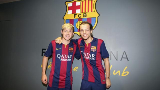 Grupo One Direction posa con las camisetas del FC Barcelona durante su visita hoy al Camp Nou. Foto EFE