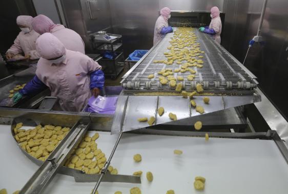 Employees work at a production line prior to a seizure at the Husi Food factory in Shanghai