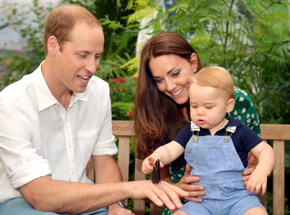 Britain's Catherine, Duchess of Cambridge, carries her son Prince George as he examines a butterfly on the hand of his father Prince William during a visit to the Sensational Butterflies exhibition at the Natural History Museum in London