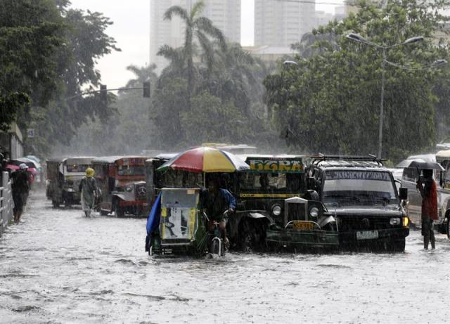 Varios vehículos circulan por una calle inundada de Manila (Filipinas) hoy, martes 19 de agosto del 2014. Toda la zona se encuentra en alerta por posibles inundaciones. EFE/Francis R. Malasig