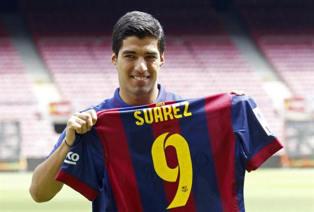 El delantero uruguayo Luis Suárez, que ha sido presentado hoy oficialmente como nuevo jugador azulgrana, cinco semanas después de fichar por el Barcelona y tras jugar ayer sus primeros minutos en el Trofeo Joan Gamper, muestra su nueva camiseta en el césped del Camp Nou. EFE/Toni Albir