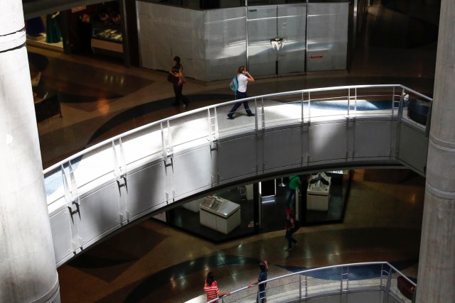 People walk in a mall in Caracas