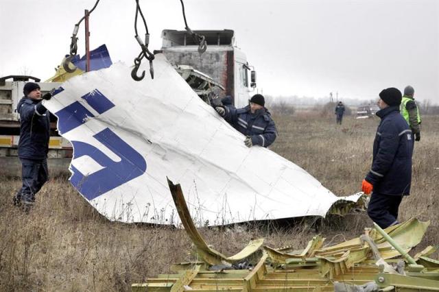 Trabajadores retiras un trozo del fuselaje del avión de pasajeros de Malaysia Airlines que fue presuntamente derribado por un misil en el este de ucrania, en Grabovo, a unos 70 km de Donetsk (Ucrania), hoy, martes 18 de noviembre de 2014. Expertos holandeses y funcionarios de los servicios de emergencia de la autoproclamada república popular de Donetsk (RPD) reanudaron ayer la recogida de restos del avión malasio en el que murieron las 298 personas que iban a bordo. EFE/Alexander Ermochenko