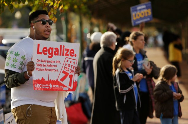 Melvin Clay of the DC Cannabis Campaign holds a sign urging voters to legalize marijuana, in Washington