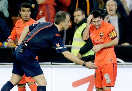 Foto:  El delantero argentino del FC Barcelona Leo Messi (d) se lamenta tras el lanzamiento de una botella, durante el partido de Liga en Primera División ante el Valencia disputado esta noche en el estadio de Mestalla / EFE