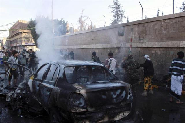 Yemenís inspeccionan el lugar donde ha explosionado un coche en Saná, Yemen, hoy, 7 de enero de 2014. A menos 33 personas murieron y más de 50 resultaron heridas en un ataque suicida hoy contra una academia de policía en Saná. El ataque fue perpetrado por un suicida al volante de un coche cargado de explosivos, que se empotró junto a un grupo de personas que se estaba registrando en la academia para formarse como agentes del orden. EFE/ABDUL-RAHMAN HWAIS