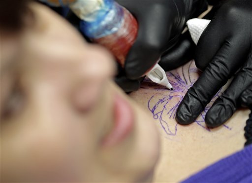 Foto: la tatuadora Ashley Neumann trabaja sobre la piel de la sobreviviente de cáncer de mama Mari Jankowski / AP