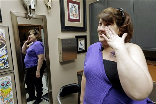 Foto: la sobreviviente de cáncer de mama Mari Jankowski llora tras ver el nuevo tatuaje que cubre una de sus cicatrices en West Allis, Wisconsin / AP