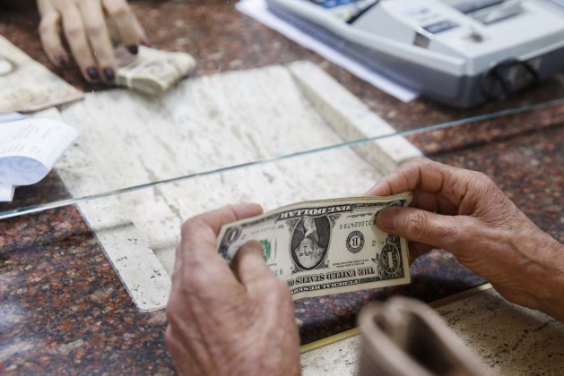 A woman change dollars for bolivars at a money exchange in Caracas