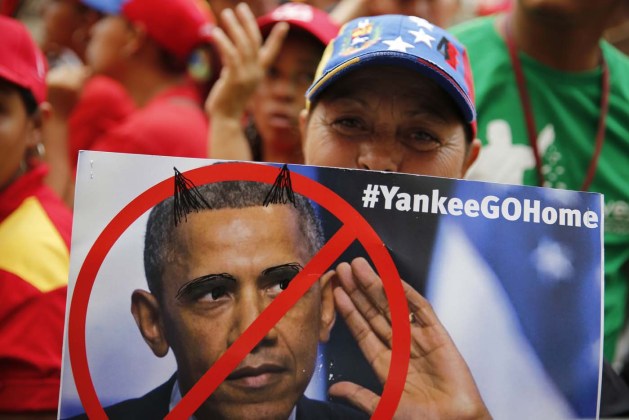 Supporter of Venezuela's President Nicolas Maduro holds a placard depicting U.S. president Barack Obama during a rally outside Miraflores Palace in Caracas