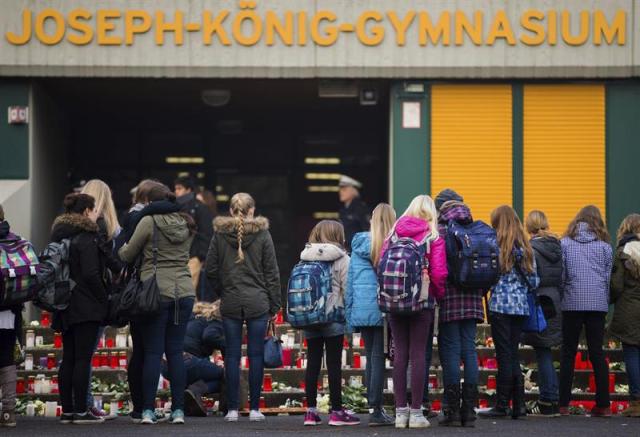 Alumnos permanecen en pie ante velas y ramos de flores en memoria de los 16 alumnos y dos profesores del instituto de Haltern am See (Alemania) fallecidos en el accidente de avión en los Alpes hoy, miércoles 25 de marzo de 2015. Los estudiantes alemanes, de 15 y 16 años de edad, habían tomado el avión ayer por la mañana desde el aeropuerto barcelonés de El Prat, después de haber abandonado horas antes en tren la localidad de Llinars del Vallès. EFE/Rolf Vennenbernd