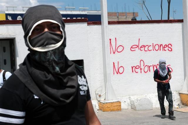 Fotografía que muestra a miembros de un grupo de apoyo a los familiares de los 43 jóvenes desaparecidos mientras pintan paredes en la ciudad de Chilpancingo, capital del estado de Guerrero (México), para boicotear las próximas elecciones. Los familiares de los 43 estudiantes desaparecidos en México realizarán tomas a embajadas de varios países en Ciudad de México el próximo 20 de marzo para "internacionalizar la demanda de la aparición con vida" de los jóvenes, informaron promotores de la iniciativa. Las manifestaciones en las representaciones diplomáticas se harán previas a una jornada de protestas en las sedes del Instituto Nacional Electoral (INE) el próximo 26 de marzo, con la que recordarán seis meses de la desaparición de los alumnos. EFE/José Luis de la Cruz