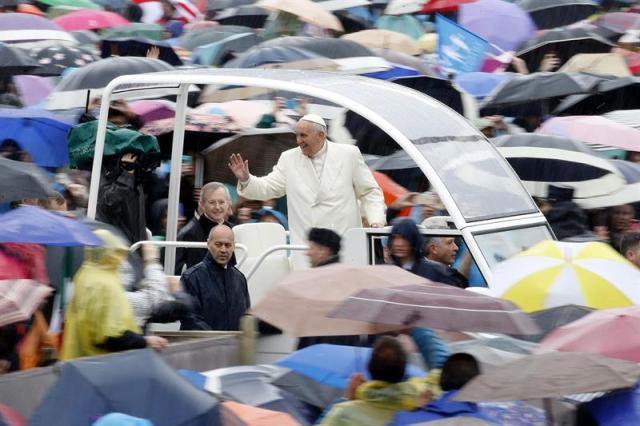 El papa Francisco saluda a los fieles a su llegada a la plaza de San Pedro del Vaticano para presidir la audiencia general de los miércoles una lluviosa mañana hoy, 25 de marzo de 2015. EFE/Fabio Frustaci