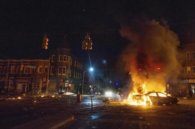 Un coche arde en la intersección de la calle norte con la calle Monroe durante los disturbios provocados durante una protesta contra la muerte de Freddie Gray en Baltimore (Estados Unidos) en la madrugada de hoy, martes 28 de abril de 2015. Los disturbios raciales en la ciudad estadounidense de Baltimore son uno de los mas graves de los últimos meses en Estados Unidos, motivados por las actuaciones policiales contra ciudadanos afroamericanos. El lunes, tras el entierro del joven, las protestas se tornaron violentas y los incendios, saqueos de tiendas y altercados contra la Policía sumieron a la ciudad en el caos total y un toque de queda. El resultado fue la detención de 27 personas y 15 policías heridos. EFE/Noah Scialom