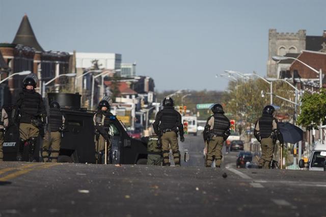 Varios policías caminan por una calle durante las labores de limpieza después de las protestas de ayer contra la muerte de Freddie Gray, en Baltimore (Estados Unidos), hoy, martes 28 de abril de 2015. Los disturbios raciales en la ciudad estadounidense de Baltimore son uno de los mas graves de los últimos meses en Estados Unidos, motivados por las actuaciones policiales contra ciudadanos afroamericanos. El lunes, tras el entierro del joven, las protestas se tornaron violentas y los incendios, saqueos de tiendas y altercados contra la Policía sumieron a la ciudad en el caos total y un toque de queda. El resultado fue la detención de 27 personas y 15 policías heridos. EFE/John Taggart