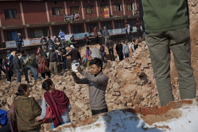 Un hombre toma un selfie, o autofoto, ante la histórica torre Dharahara, un monumento destacado de la capital de Nepal, que resultó dañada en el fuerte terremoto del sábado en Katmandú, Nepal, el 27 de abril de 2015. (Foto AP/Bernat Armangue)