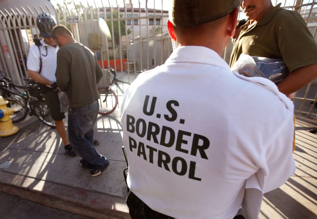 NOGALES, AZ - JUNE 02:  An U.S. Customs and Border Protection bike patrol agent assists Mexican's being returned to Mexico after they were apprehended for entering the United States illegally June 2, 2010 in Nogales, Arizona. A fence which separates the cities of Nogales, Arizona and Nogales, Sonora Mexico is a frequent crossing point for people entering the United States illegally. During the 2009 fiscal year 540,865 undocumented immigrants were apprehended entering the United States illegally along the Mexican border, 241,000 of those were captured in the 262 mile stretch of the border known as the Tucson Sector.  (Photo by Scott Olson/Getty Images)