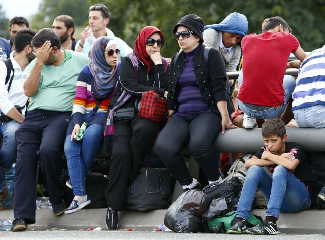 Inmigrantes esperan para cruzar la frontera de Austria hacia Alemania, cerca de Freilassing, Alemania, 17 de septiembre de 2015. El jefe de la oficina de refugiados en Alemania, que ha sido criticado por el manejo de la llegada de un número récord de refugiados que buscan asilo en el país, renunció a su cargo, dijo el jueves el Ministerio del Interior. REUTERS/Michaela Rehle