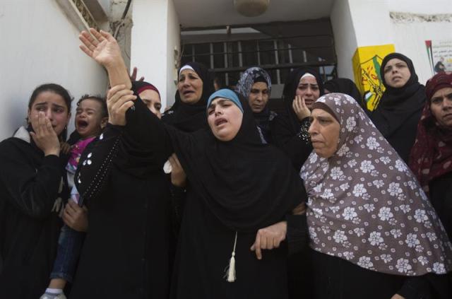 La madre de Ahmad Sharaka, un adolescente palestina que fue abatido a tiros en el campo de refugiados cisjordano de Jalazoun durante su funeral celebrado en Palestina hoy 12 de octubre de 2015. La región vive una oleada de violencia que dura ya doce días y que ha causado cuatro israelíes muertos y más de una veintena de heridos y la muerte de 25 palestinos (siete de ellos supuestos atacantes) y heridas a alrededor de un millar. EFE/Atef Safadi