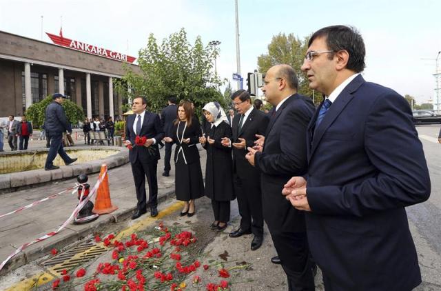 Fotografía facilitada por la oficina de prensa del primer mininstro que muestra al primer ministro turco, Ahmet Davutoglu (3º dcha), y a su mujer Sare (4º dcha), mientras visitan el lugar del doble atentado, perpetrado el pasado 10 de octubre, en Ankara Turquía, 13 de octubre de 2015 / EFE