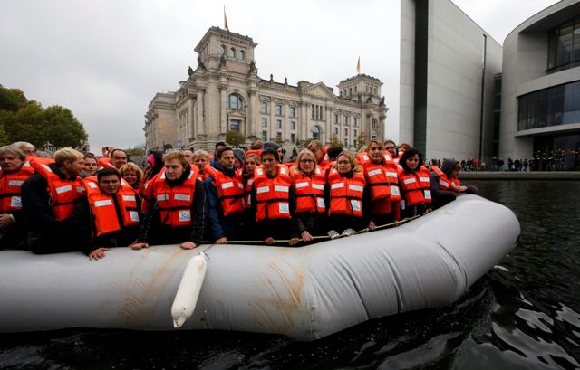 An original dingy used by migrants carries members of the parliament and volunteers on the river Spree to show conditions under which migrants cross the Mediterranean Sea, during an event organized by German NGO Sea-Watch in front of the Reichstag building in Berlin, Germany October 13, 2015. REUTERS/Fabrizio Bensch