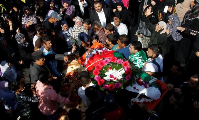 Palestinos ondean banderas durante el entierro de Muhammed Shamasne en Qatna (Palestina) hoy, 2 de noviembre de 2015. El gobierno israelí entregó ayer los cuerpos sin vida de dos palestinos que fueron abatidos tras atacar a israelíes tras exigir a las autoridades palestinas que se mantendría la calma durante sus entierros. Además, Israel ha exigido que los rituales se celebren por la noche y sólo a los familiares más cercanos para evitar que se glorifique a los fallecidos. EFE/Alaa Badarneh