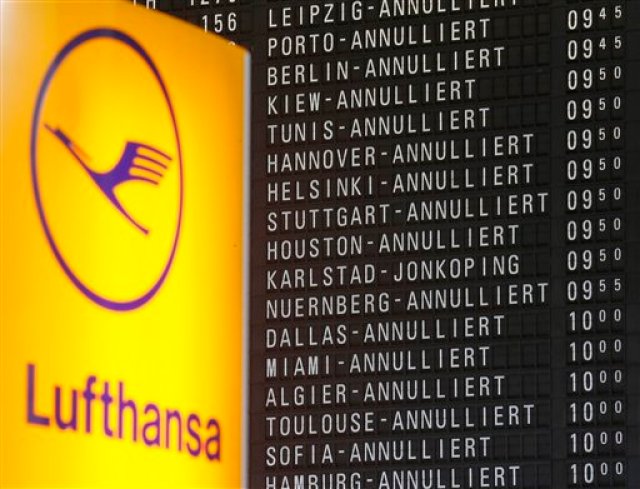 Un panel del aeropuerto de Fráncfort, en Alemania, muestra los vuelos cancelados por una huelga de las tripulaciones de cabina de la aerolínea germana Lufthansa, junto a un logo de la compañía, el 9 de noviembre de 2015. (Foto AP/Michael Probst)