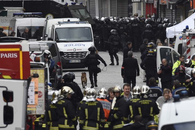 Firefighters and policemen are gathered in the northern Paris suburb of Saint-Denis city center, on November 18, 2015, as French Police special forces raid an appartment, hunting those behind the attacks that claimed 129 lives in the French capital five days ago. At least one person was killed in an apartment targeted in the operation aimed at the suspected mastermind of the attacks, Belgian Abdelhamid Abaaoud, and police had been wounded in the shootout.     AFP PHOTO / LIONEL BONAVENTURE