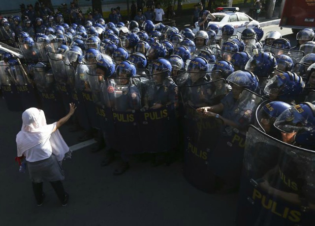 Policías antidisturbios vigilan una manifestación en contra de la celebración de la Cumbre de Líderes del Foro de Cooperación Económica Asia Pacífico (APEC) en Manila (Filipinas) hoy, 19 de noviembre de 2015. EFE/Mark R. Cristino