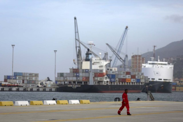 A port worker walks by the main dock at the port in La Guaira, November 12, 2015. Hit by recession and the oil price plunge, Venezuela's cash crunch has stymied President Maduro's bid to fill empty shelves with imported meat and medicines ahead of Sunday's legislative election that his socialist government may lose. Picture taken November 12, 2015. REUTERS/Marco Bello. FOR EDITORIAL USE ONLY. NO RESALES. NO ARCHIVE.