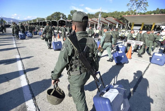 Members of the Venezuelan army walk with electoral machines in Caracas on December 1, 2015. The Venezuelan opposition on Monday urged the armed forces to ensure that the results of the legislative elections of next Sunday are respected.   AFP   PHOTO/JUAN BARRETO / AFP / JUAN BARRETO