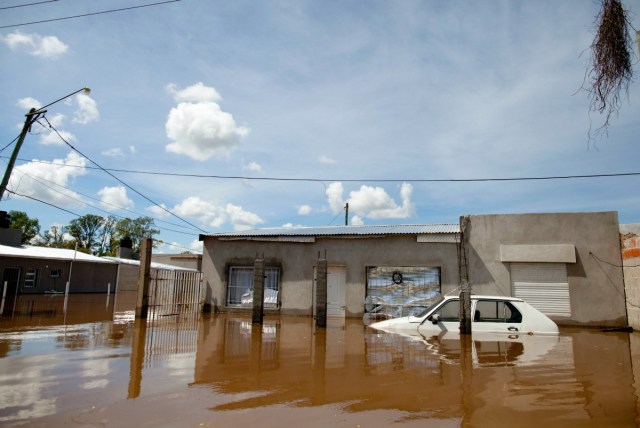 Un automóvil y casas sumergidas en el agua por la inundación en Concordia, Argentina, el lunes, 28 de diciembre de 2015. Al menos 20.000 personas han sido evacuadas en Argentina. El vecino Paraguay ha sido el más afectado con 100.000 evacuados. También hay evacuados en Uruguay y el sur de Brasil. (AP Foto/Natacha Pisarenko)