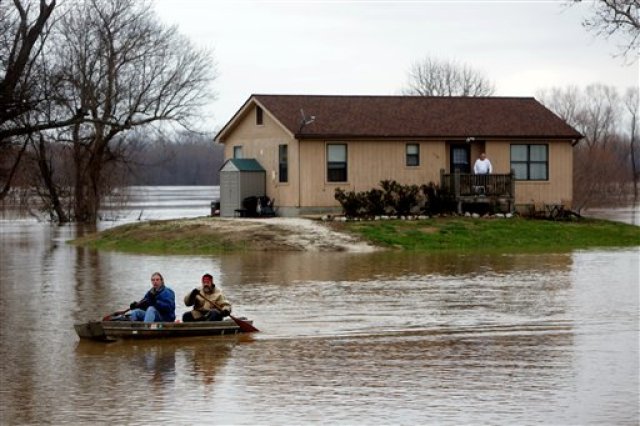 Scott Fox, al frente, decidió que era hora de dejar su residencia en Mississippi Boulevard, rodeada por el agua, y rema con su amigo Tony Watkins en Kimmswick, Missouri, el jueves 31 de diciembre de 2015. (Laurie Skrivan/St. Louis Post-Dispatch via AP)