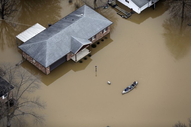 En esta fotografía aérea, algunas personas se transportan en canoa en una calle inundada, el jueves 31 de diciembre de 2015, en Arnold, Missouri. El desborde de algunos ríos de la región centro-norte de Estados Unidos obligó a evacuar a cientos de personas, amenazó decenas de diques y prácticamente paralizó el transporte por automóvil, bote y tren en la zona metropolitana de St. Louis. (Foto AP/Jeff Roberson)