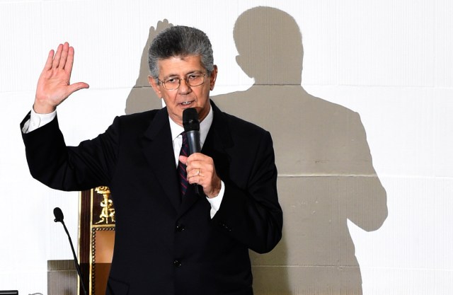 The new president of the Venezuelan parliament, Henry Ramos Allup raises his hand during the swearing-in ceremony in Caracas, on January 5, 2016.  Venezuela's President Nicolas Maduro ordered the security forces to ensure the swearing-in of a new opposition-dominated legislature passes off peacefully Tuesday, after calls for rallies raised fears of unrest. AFP PHOTO/JUAN BARRETO / AFP / JUAN BARRETO