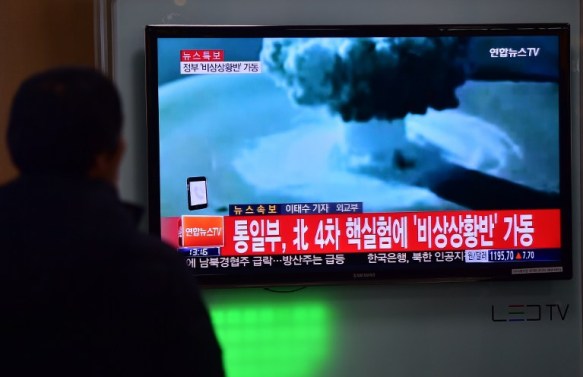 La gente ve un informe de prensa el primero de hidrógeno prueba de la bomba de Corea del Norte en una estación de ferrocarril en Seúl el 6 de enero de 2016. Corea del Sur "fuertemente" condenó prueba de la bomba de hidrógeno de choque de Corea del Norte y se comprometió a tomar "todas las medidas necesarias" para penalizar su nucleares vecino armado. La imagen que se muestra en la televisión muestra archivos de imágenes de otras pruebas nucleares de otros países y la leyenda en rojo en la parte inferior de la pantalla se lee "la Casa Azul convocará una reunión de emergencia del Consejo de Seguridad Nacional, el Consejo Nacional de Seguridad." AFP PHOTO / JUNG YEON-JE