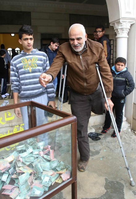 Un hombre suní libanesa dona dinero para la gente de la ciudad sitiada siria de Madaya al salir de la mezquita, el 8 de enero de 2016, en la ciudad portuaria sureña de Sidón. Gobierno sirio dio permiso el 7 de enero de 2016, para las entregas de ayuda de la ONU para tres ciudades sitiadas, incluyendo Madaya cerca de Damasco, donde los residentes dicen que la gente está muriendo de hambre. AFP PHOTO / MAHMOUD Zayyat