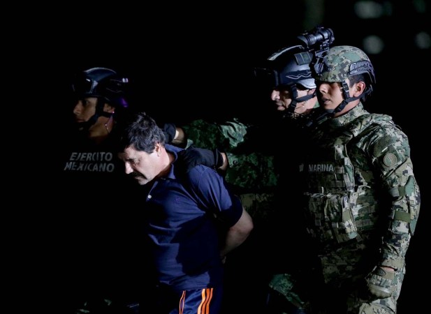 Recaptured drug lord Joaquin "El Chapo" Guzman is escorted by soldiers at the hangar belonging to the office of the Attorney General in Mexico City, Mexico January 8, 2016. REUTERS/Henry Romero