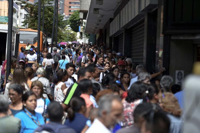 People line up to buy basic food and household items outside a supermarket in Caracas, Venezuela on January 21, 2016. Trade unions demonstrated Wednesday outside the Venezuelan National Assembly against the economic emergency decrees issued by President Nicolas Maduro, who was meeting with the legislative commission studying whether parliament will approve the executive measures.  AFP PHOTO/JUAN BARRETO / AFP / JUAN BARRETO