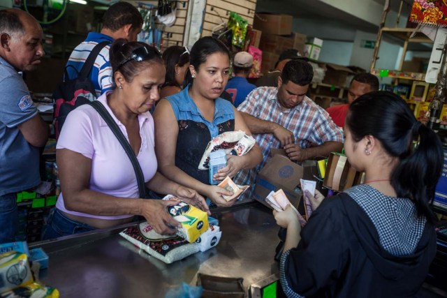 CAR01. CARACAS (VENEZUELA), 16/01/2016.- Clientes hacen fila para pagar productos que compraron en un abasto hoy, sábado 16 de enero de 2016, en la ciudad de Caracas (Venezuela). Venezuela, con las mayores reservas probadas de petróleo del mundo, se declaró en emergencia económica para atender la situación del país que después de un año de opacidad reveló una inflación interanual de 141,5 por ciento -la más alta de toda su historia-, y una contracción del 4,5 por ciento. EFE/MIGUEL GUTIÉRREZ