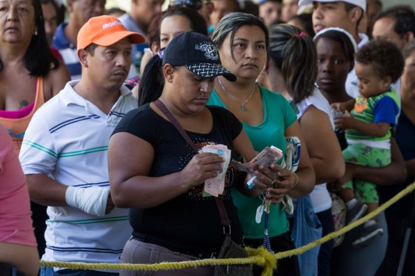 CAR01. CARACAS (VENEZUELA), 23/01/2016.- Una mujer cuenta dinero mientras hace fila para comprar una bolsa con alimentos en una venta realizada en un edificio del plan habitacional gubernamental "Misión Vivienda" hoy, sábado 23 de enero de 2016, en la ciudad de Caracas (Venezuela). El presidente del Parlamento venezolano, el opositor Henry Ramos Allup, reiteró hoy que los problemas que afronta su país con una aguda crisis económica de carestía y escasez se agravarán si Nicolás Maduro sigue en la jefatura del Estado. La situación económica del quinto productor de petróleo del mundo se ha visto golpeada por la caída de los precios del crudo, que inició en septiembre de 2014 cuando se cotizaba en 90 dólares por barril y que cerró esta semana en 21,63 dólares. "Este Gobierno va a resolver nada; mientras esté allí todos los problemas de Venezuela van a empeorar totalmente. Hasta que no salgamos democráticamente de este Gobierno, Venezuela no se va a recuperar ni podrá resolver ninguno de sus problemas", subrayó en un discurso ante manifestantes antigubernamentales en Caracas. EFE/MIGUEL GUTIERREZ