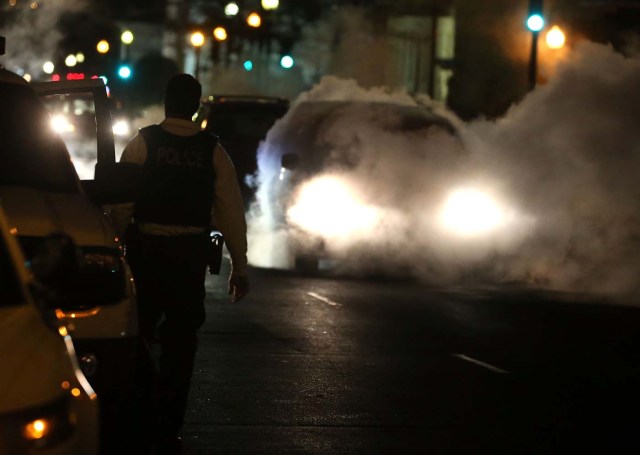 WASHINGTON, DC - JANUARY 26: A car passes over a steam grate while a police officer stands nearby on 17th st. January 26, 2016 in Washington, DC. The east coast is still digging out from large storm that hit the east cost over the weekend, breaking snowfall records, causing 29 storm-related deaths, and serious flooding in coastal areas.   Mark Wilson/Getty Images/AFP