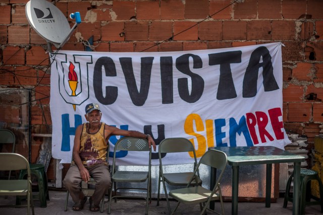 Un hombre espera para ser atendido el sábado pasado por estudiantes de odontología que dan los exámenes sin costo. La pancarta habla de los estudiantes de la UCV “hoy y siempre”. PHOTO: MIGUEL GUTIÉRREZ PARA THE WALL STREET JOURNAL.