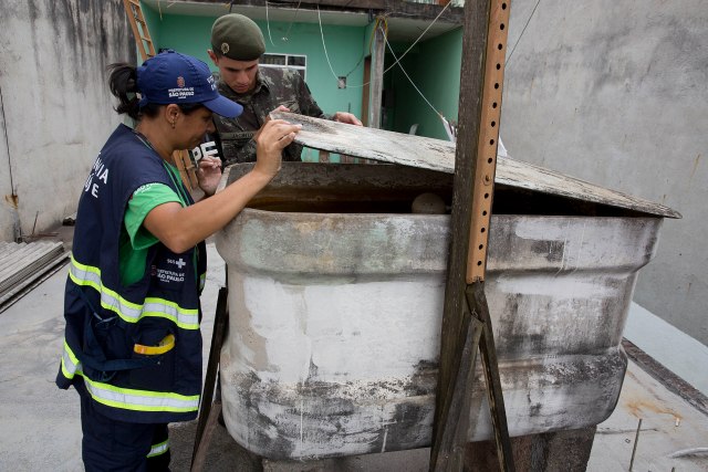 Un soldado y una trabajadora de la secretaría de salud revisan un contenedor de agua durante una campaña para combatir al mosquito portador del virus del zika en Sao Paulo el 28 de enero del 2016. La presidenta brasileña Dilma Rousseff pidió una reunión de los países de América Latina y el Caribe para coordinar la lucha contra el brote de zika.  (AP Photo/Andre Penner)