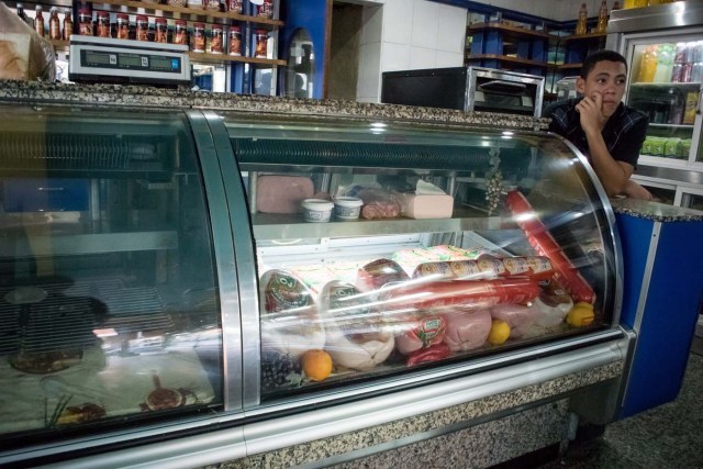 CAR11. CARACAS (VENEZUELA), 11/02/2016.- Un joven espera los clientes en una tienda hoy, jueves 11 de febrero de 2016, en Caracas (Venezuela). El Parlamento venezolano declaró hoy la "crisis alimentaria nacional" y en virtud de ello pidió que la FAO y la Unicef envíen expertos que evalúen los riesgos que entraña el problema para los 30 millones de habitantes del país caribeño. EFE/Miguel Gutiérrez