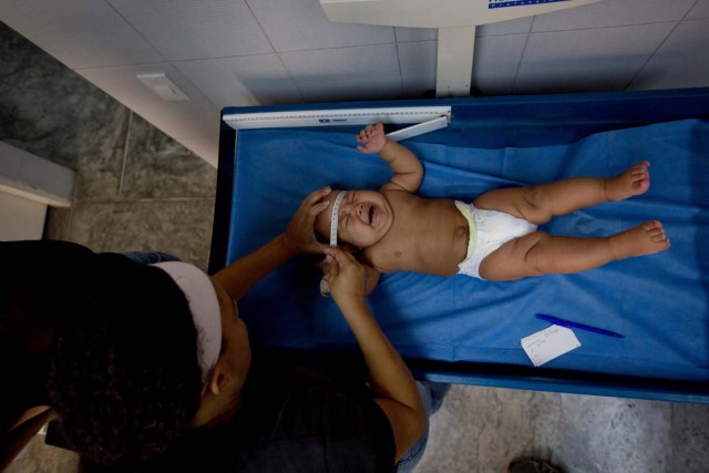 En esta foto del 11 de febrero de 2016, una enfermera mide la cabeza de un bebé durante un examen médico de rutina en una clínica en el barrio de Petare en Caracas, Venezuela. Ante la crisis del sistema de salud y la profunda escasez de medicamentos que agobia Venezuela, lo último que cualquier venezolano quiere es enfermarse. Y menos del virus del zika. Actualmente, no se consigue repelente para insectos, ni anticonceptivos para evitar embarazos, ni medicamentos para tratar las enfermedades asociadas al virus. (Foto AP / Fernando Llano)