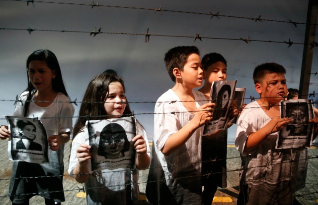 Los niños actores que retrata hijos de personas que murieron durante el estado de sitio, mantenga las imágenes de las víctimas de la ley marcial, dentro de un Experiential Museum Poder Popular en un campamento de Aguinaldo militar en Quezon City, Metro Manila 24 de de febrero de, 2016, un día antes de los 30 años de las personas EDSA revolución del poder. REUTERS / Erik De Castro